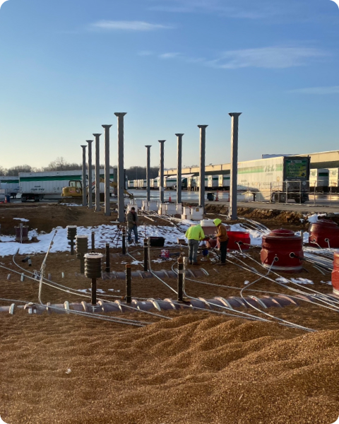 Workers installing foundation and concrete pillars for industrial building project by Heartland Building Group
