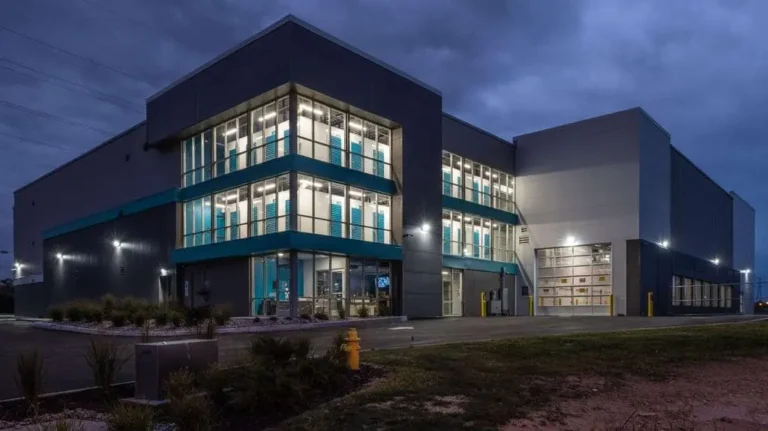 Exterior view of a modern self-storage facility with multi-story units and glass windows